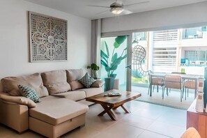 Ein modernes Wohnzimmer mit einer Couch, einem Couchtisch und einem großen Fenster.