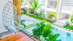 Ein modernes Hotelinnere mit Schwimmbad, Außenbereich zum Sitzen und üppiger Bepflanzung.