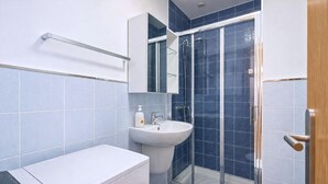 A modern bathroom with a shower, sink, and toilet. - GuestReady - Rosamar P Apartments (Las Palmas de Gran Canaria)