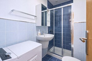 A modern bathroom with a shower, sink, and toilet. - GuestReady - Rosamar P Apartments (Las Palmas de Gran Canaria)