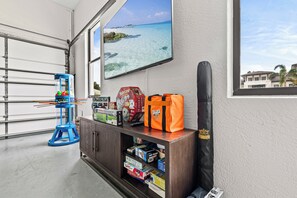 Ein Zimmer mit Meerblick, ein blauer Wasserspender, ein Regal mit Gesellschaftsspielen und eine schwarze Tasche mit einem Kronen-Logo.