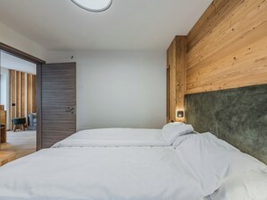 Ein Schlafzimmer mit einem Bett, Holzwandverkleidung und einem Nachttisch mit Lampe.