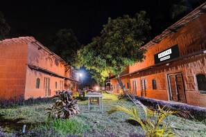 A courtyard with a table and chairs, a hanging swing, and a building with a sign reading 'PALETTE.'