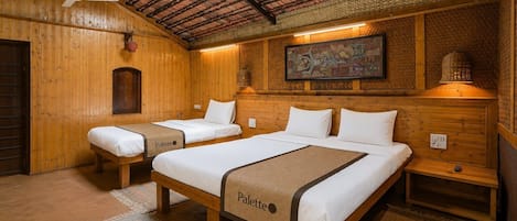 A wooden room with two beds, a ceiling fan, and a wall-mounted lamp.