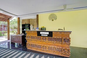 A reception desk with a sign reading 'PALLETTE' and a decorative wall clock.