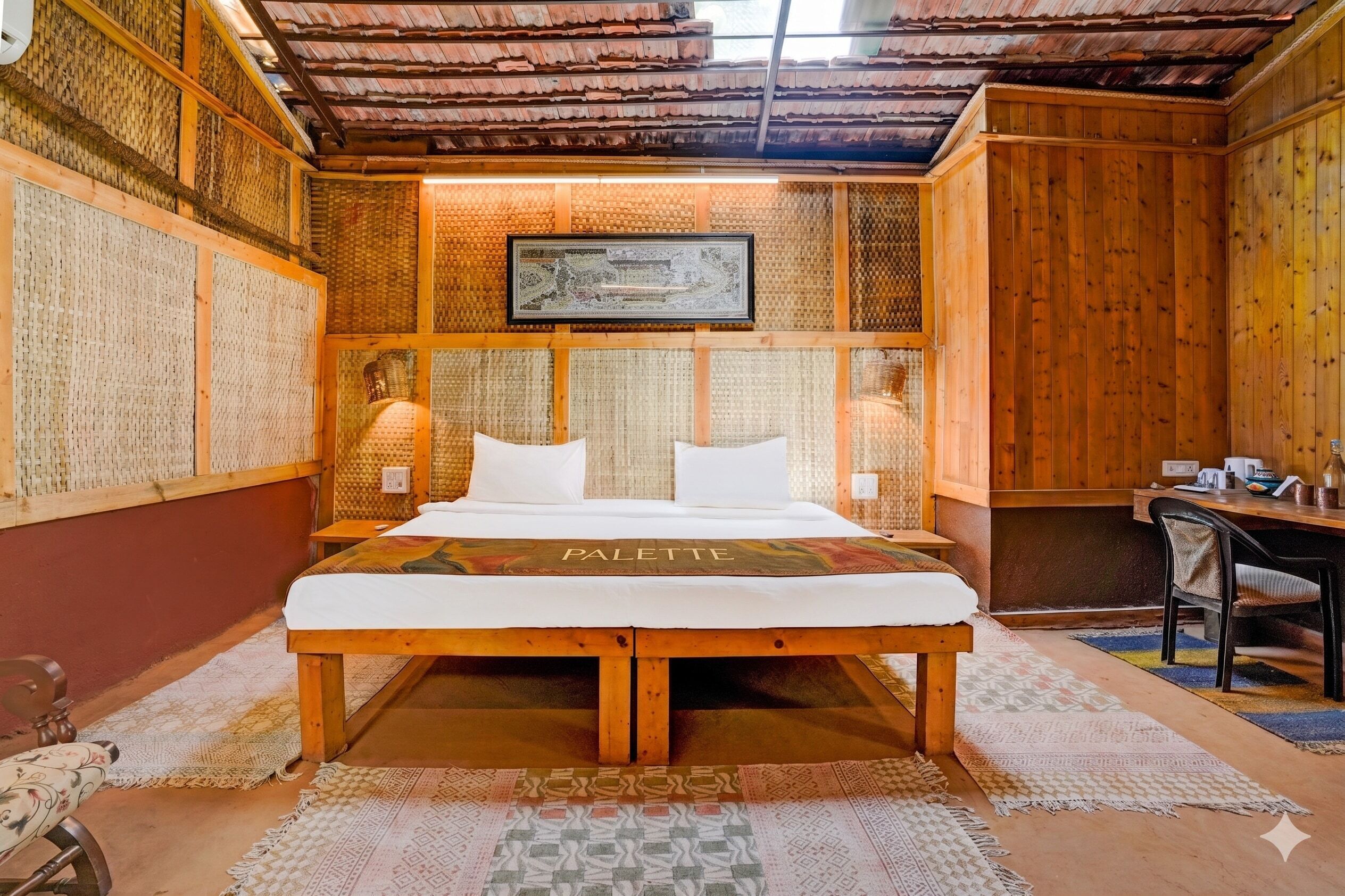 Una habitación con una cama, un escritorio y un cuadro en la pared.