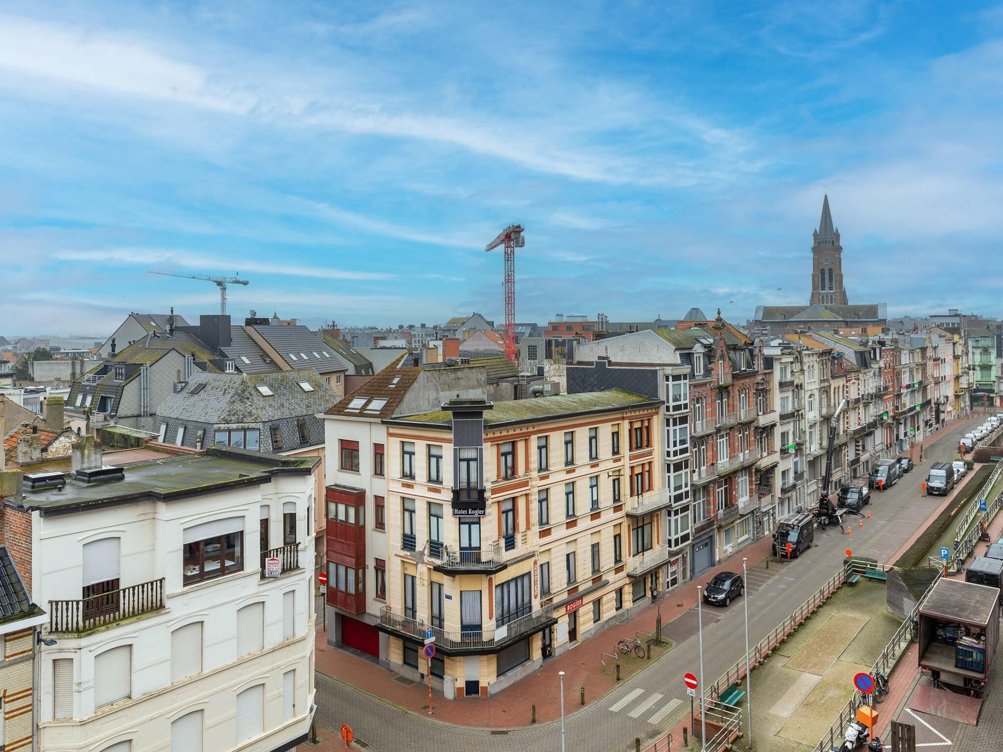A row of historic buildings with a prominent clock tower in the background.
