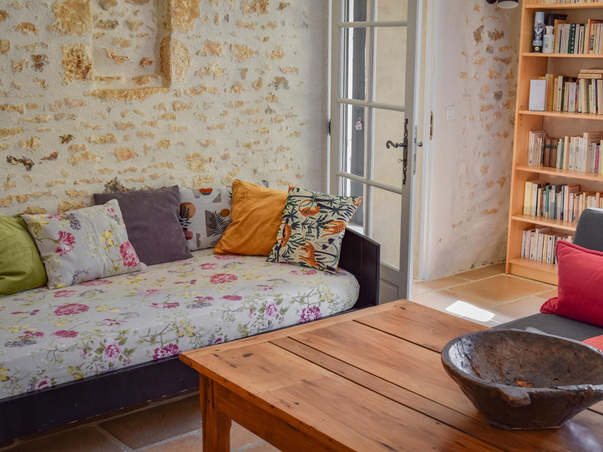Una habitación con un sofá, una mesa de madera y una estantería.