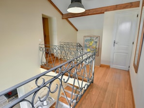 Eine Treppe mit aufwendiger Metallreling, die zu einem Holzboden führt.