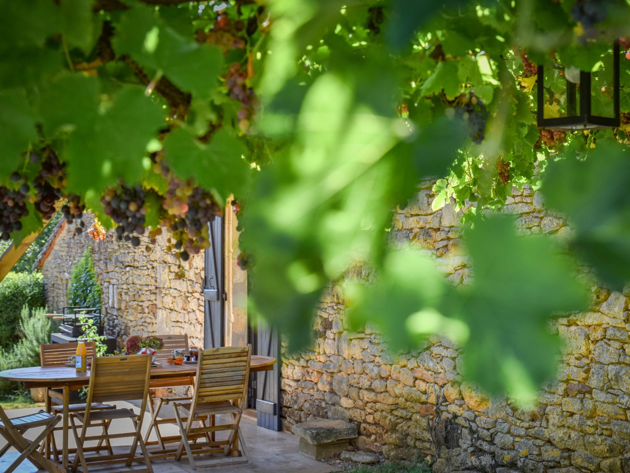 An outdoor dining area with stone walls and wooden furniture.