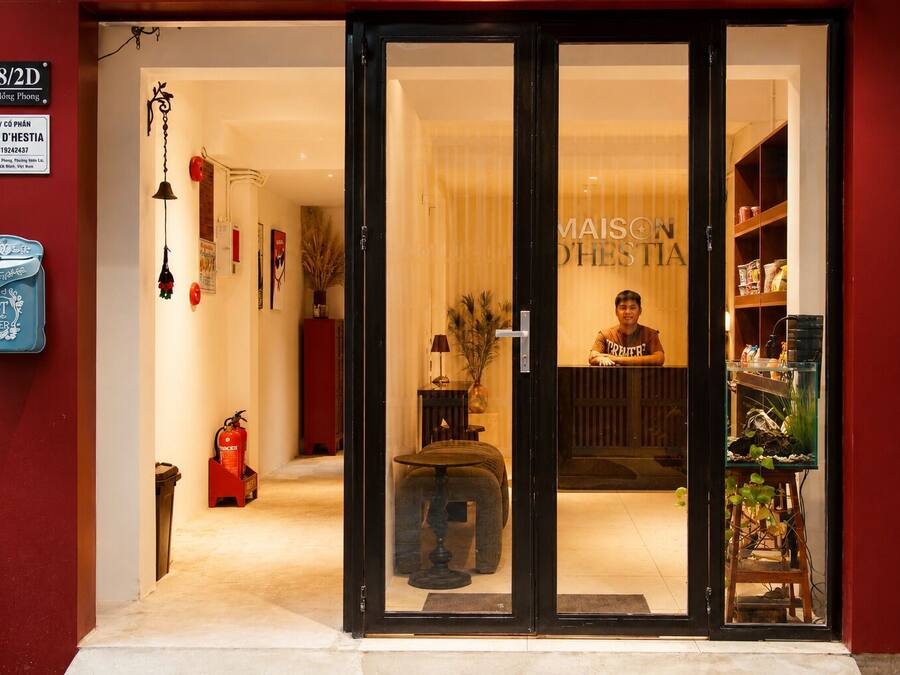 Entrada de hotel con mostrador de recepción, extintor y cartelera visible.
