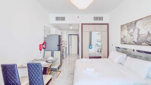 Ein Hotelzimmer mit einem Bett, einem Schreibtisch mit Stuhl, einem Spiegel und einem Bild an der Wand.