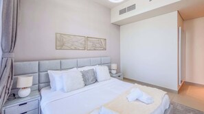 A hotel room with a bed, nightstands, a lamp, a wall-mounted artwork, and a wardrobe. - Harbour View 2BR - High Floor - Creek Harbour (Dubai)
