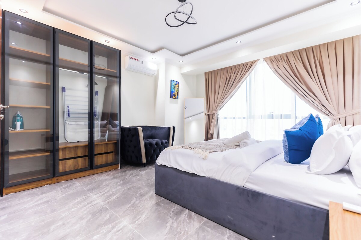 Un dormitorio moderno con una cama grande, un armario y una zona de estar.