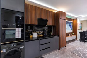 Una cocina moderna con electrodomésticos integrados, armarios de madera y un televisor de pantalla plana en la pared.