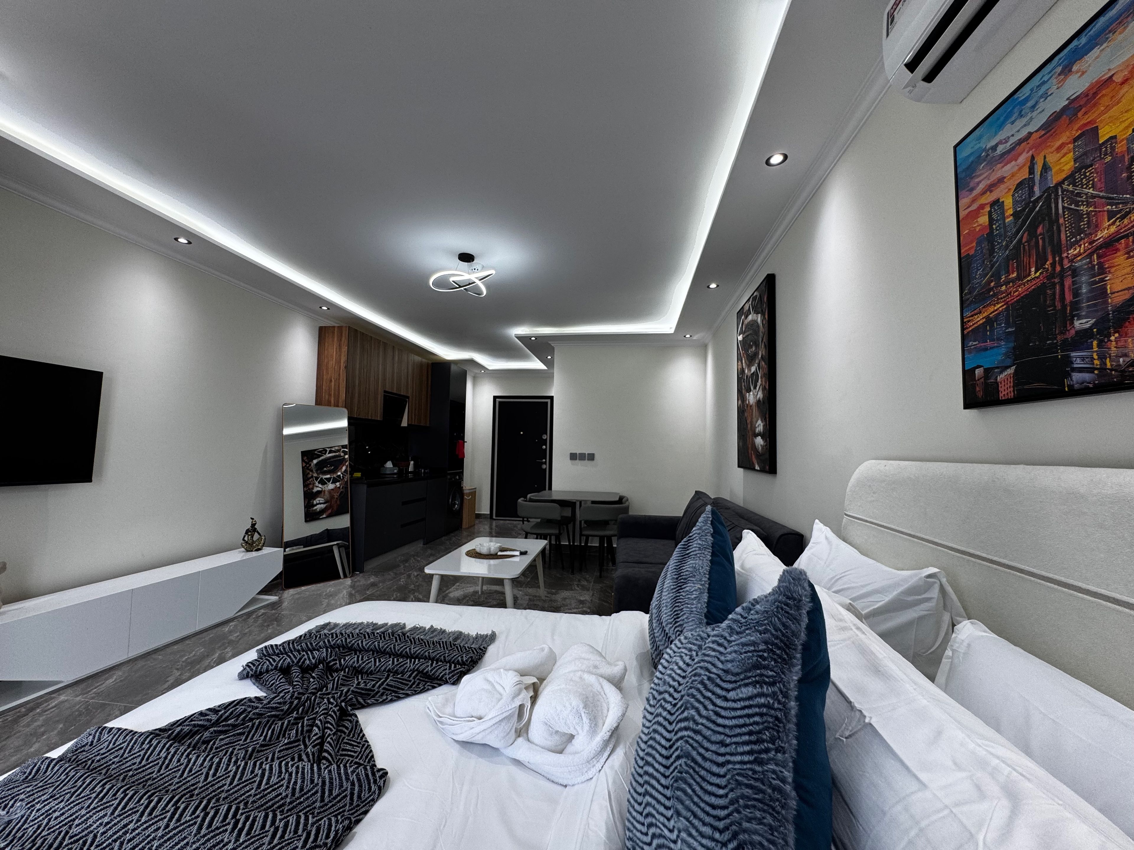 Ein modernes Hotelzimmer mit einem Bett, einem Schreibtisch, einer Sitzecke und einem Bild an der Wand.