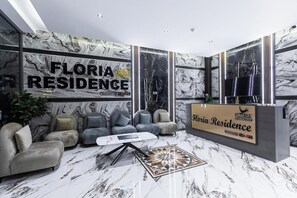A modern lobby with a reception desk, sofas, and a marble floor. - Floria 807B (Accra)