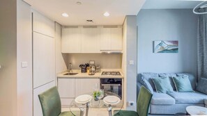 Un espacio habitable compacto con kitchenette, comedor y sofá.