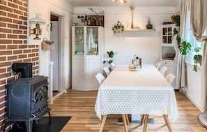 A dining area with a long table, white cabinets, and a brick wall. - 5 bedroom lovely home in Syvde (Syvde)