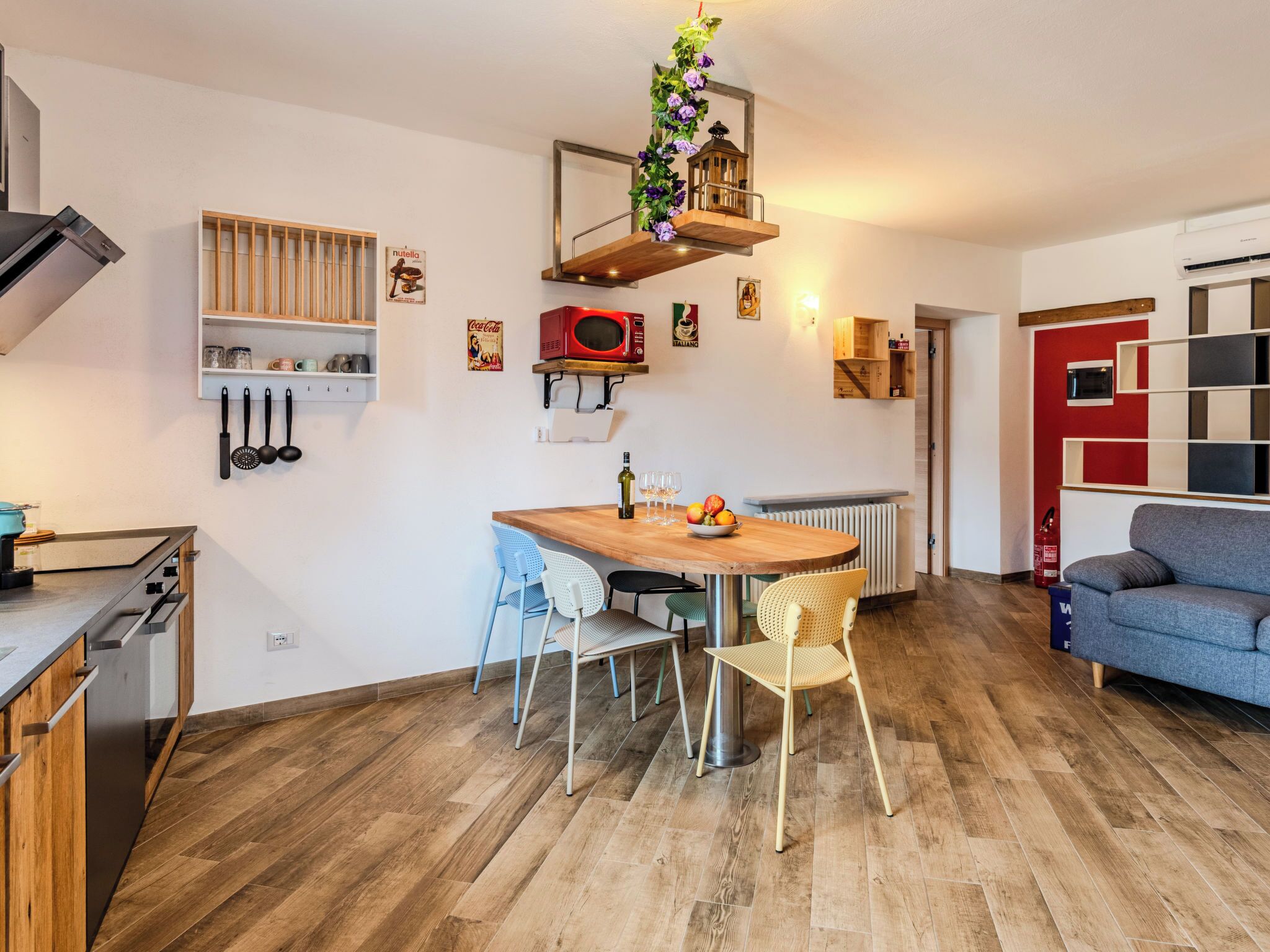 Eine moderne Küche mit Holzschränken, einem eingebauten Herd und einem Essbereich mit Holztisch und -stühlen.