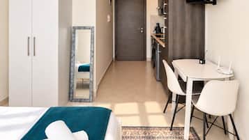 Une chambre d’hôtel équipée d’un lit, d’un bureau, d’une chaise, d’une télévision et d’une armoire.