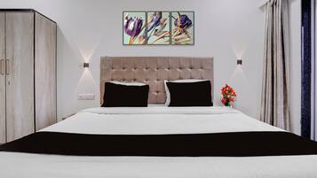 A bedroom with a large bed, a headboard, a wardrobe, and a wall-mounted light fixture.