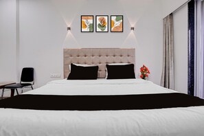 Une chambre d’hôtel moderne avec un grand lit, une chaise, une table de chevet et une fenêtre avec des rideaux.