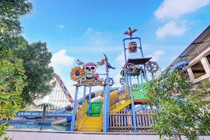 Un parc aquàtic amb una atracció de temàtica pirata, incloent un cartell de crani i ossos, un timó de vaixell i un cap de lleó.