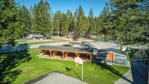 A recreational area with a basketball court, a covered seating area, and a mural with a message. - Mountain Hearth - a RidgeView Resort Partner Property (Radium Hot Springs)