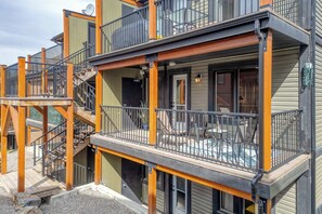 Un edificio de varios pisos con terraza exterior y una escalera.