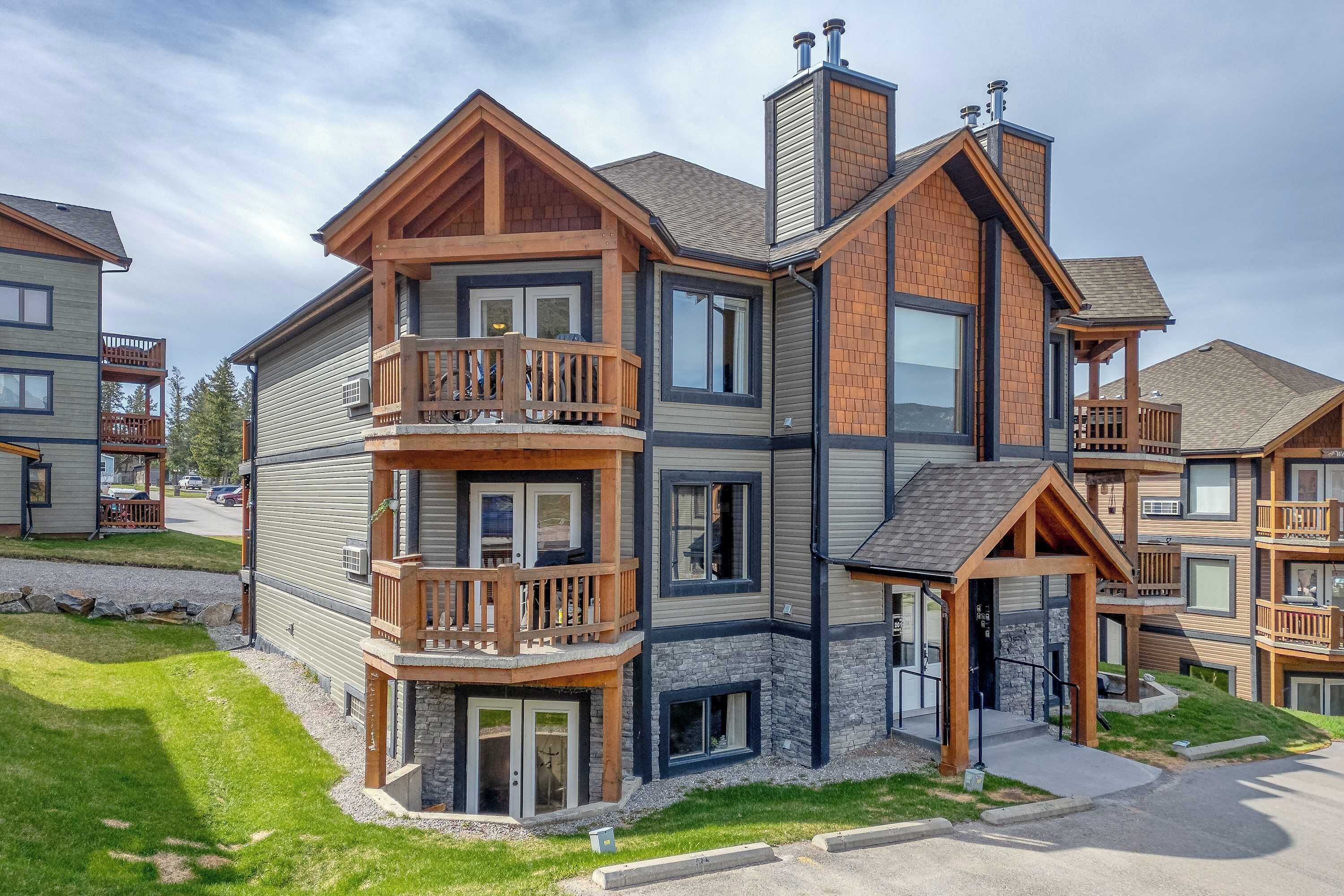 A multi-story building with balconies, a covered entrance, and a stone facade.