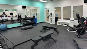 A gym with exercise equipment, a water dispenser, and a mirror. - Mountain Hearth - a RidgeView Resort Partner Property (Radium Hot Springs)