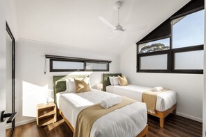 A hotel room with two beds, a ceiling fan, a window with a view, and a bedside table with a lamp. - Stone River Villa 4 | Serene Escape | Heated Pool (Margaret River)