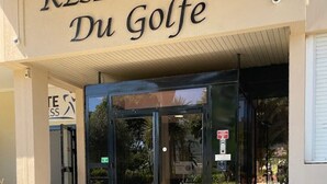 A building entrance with a revolving door, a sign reading 'RESIDENCE DU Golfe,' and a wheelchair accessibility sign. - 06. Bright One-Bedroom Apartment with Terrace, Pool, Tennis Court and Garage (Vallauris)