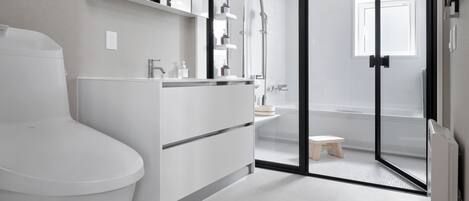 Une salle de bain moderne comprenant des toilettes, un meuble-lavabo et un espace douche.