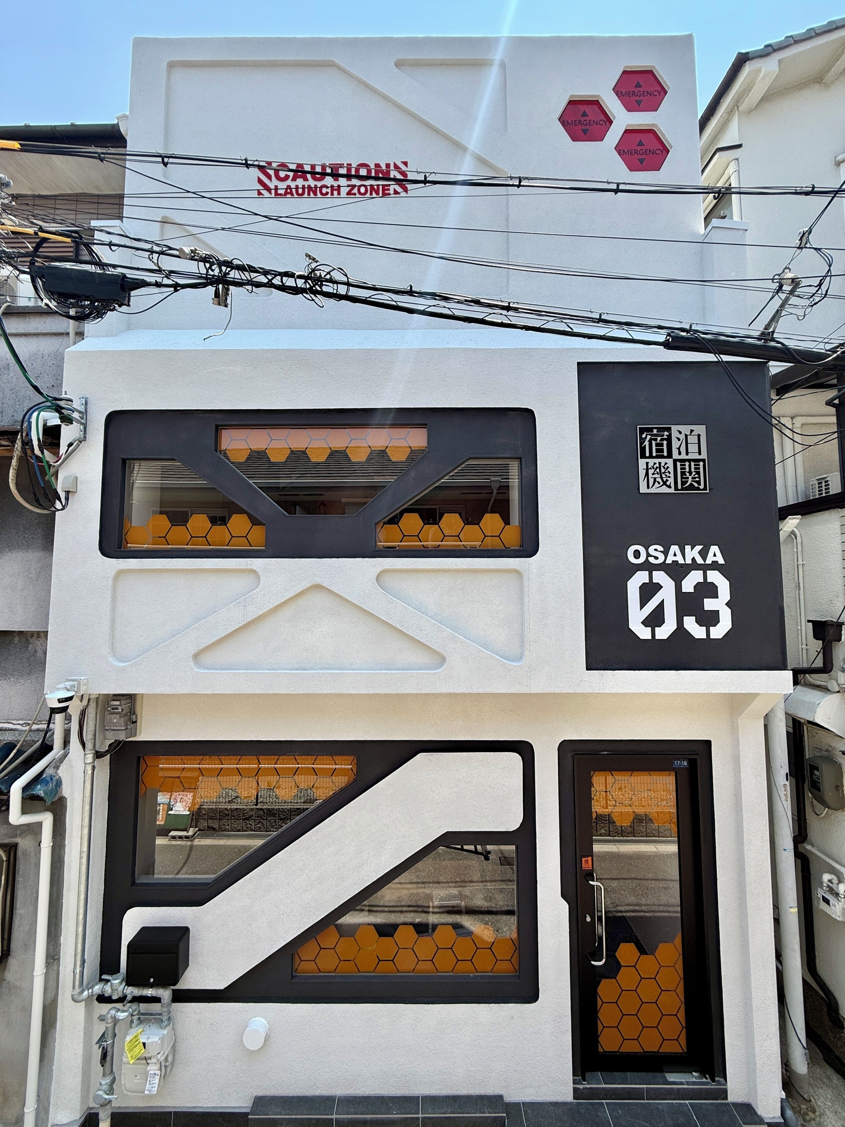 A building with a sign indicating 'OSAKA 03' and a 'CAUTION NO LAUNCH ZONE' sign above.