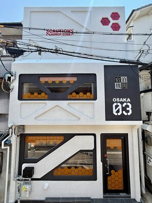 A building with a sign indicating 'OSAKA 03' and a 'CAUTION NO LAUNCH ZONE' sign above. - OSAKA-03 (Osaka)