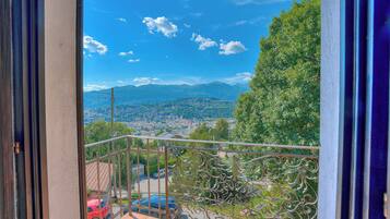 Ein Balkon mit Blick auf eine Stadtlandschaft und Berge.