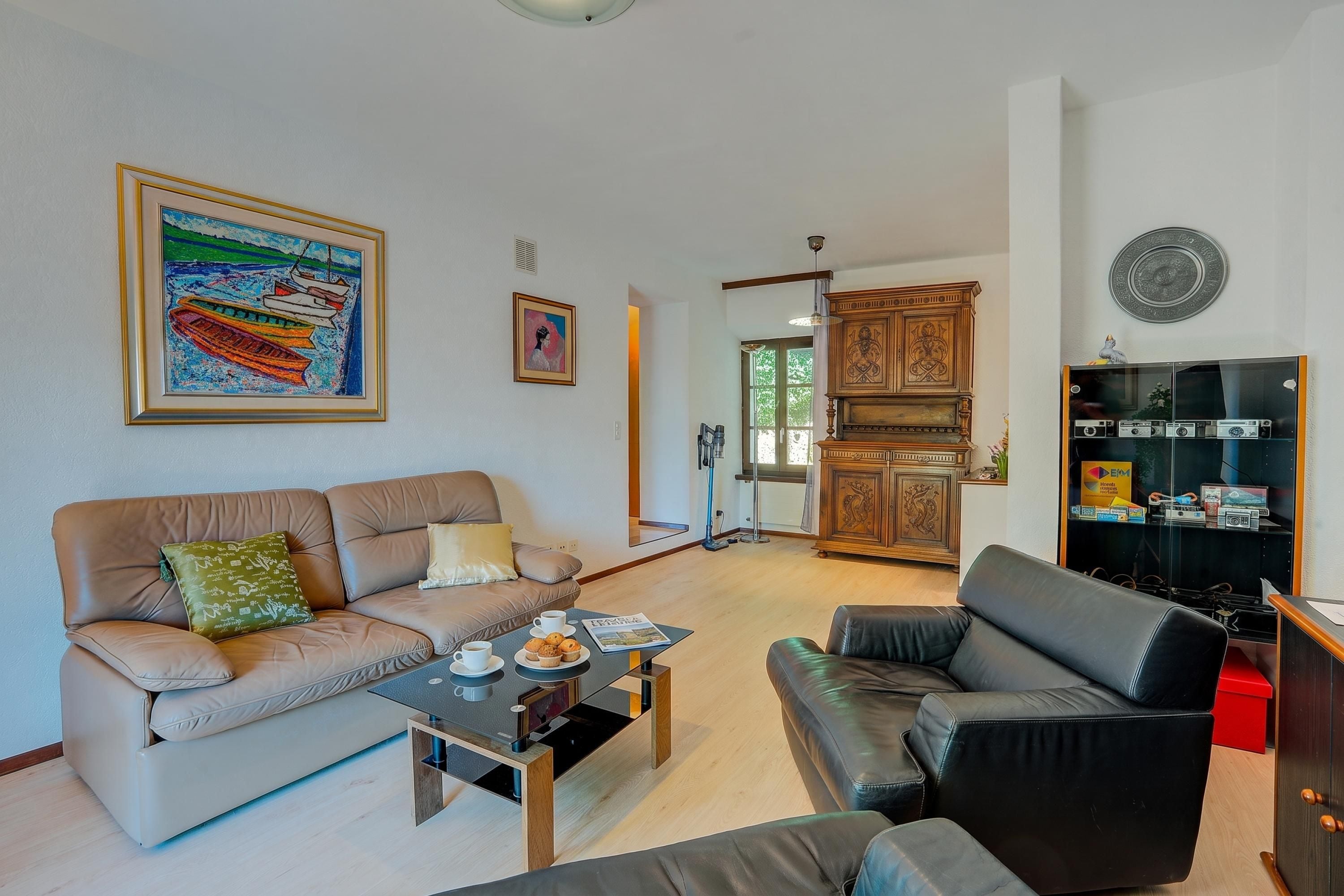 A living room with a sofa, coffee table, and a cabinet with audio equipment.