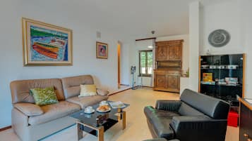 Ein Wohnzimmer mit einer Couch, einem Couchtisch und einer Anrichte mit Audioanlage.