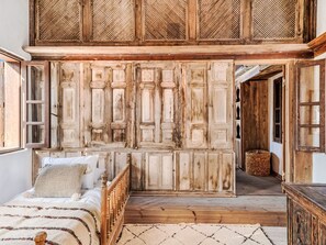 A bedroom with a bed, a wooden wardrobe, and a window. - Vasilikos Mansion by Interhome (Pefki)