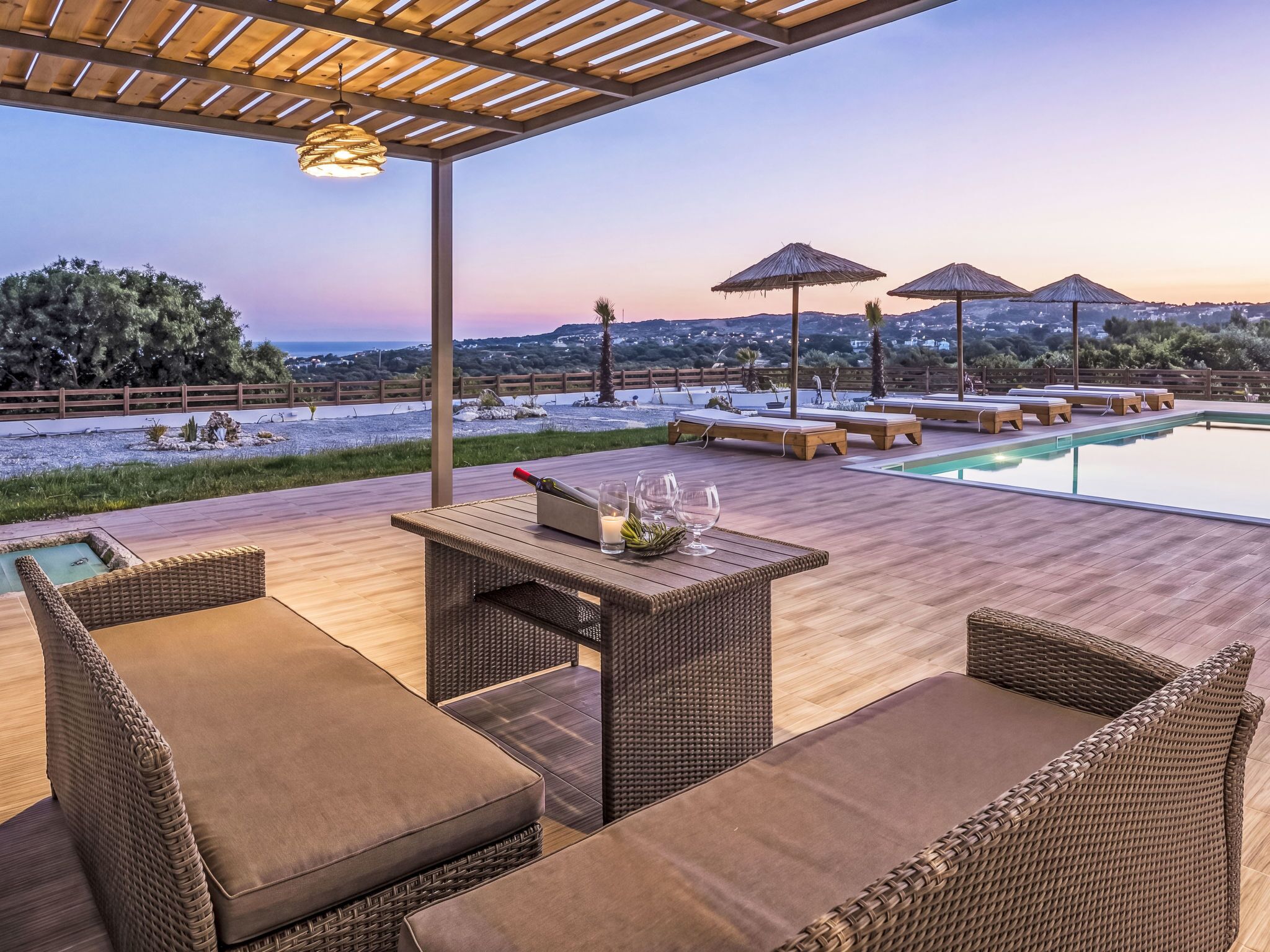 Un espace extérieur abrité comprenant une piscine, des chaises longues et une vue sur le paysage.