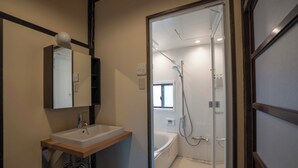 A modern bathroom with a sink, mirror, and shower. - Magoichi: A Traditional Japanese House Condominium Available for Entire-Property Rentals (加賀市橋立町)