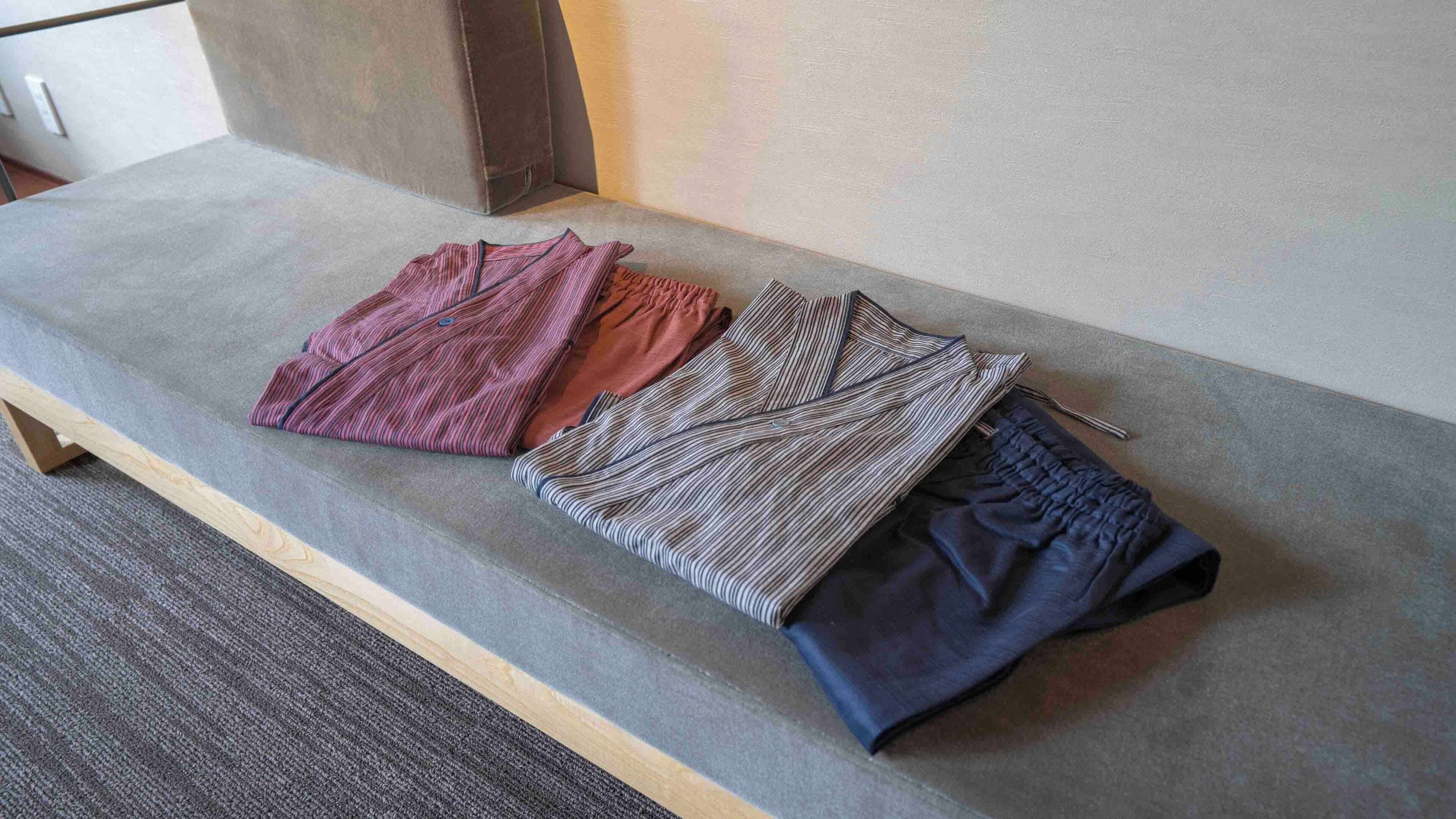 A bench with folded clothing items.