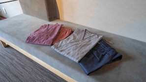 A bench with folded clothing items.
