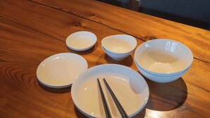 A wooden table with five white bowls and chopsticks. - Magoichi: A Traditional Japanese House Condominium Available for Entire-Property Rentals (加賀市橋立町)