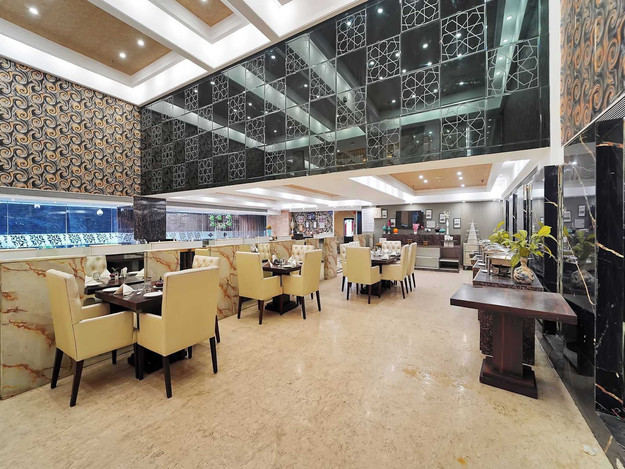 A spacious hotel lobby with a high ceiling, marble flooring, and a modern design.