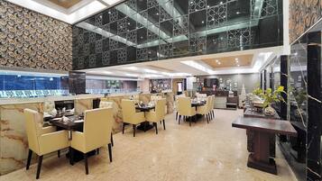 A spacious hotel lobby with a high ceiling, marble flooring, and a modern design.