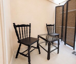 A corner room with two black chairs and a glass table. - Modern Basement Studio - Kolonaki by ΜΡS (Athina)