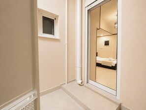 Ein Hotelzimmer mit großem Spiegel, einem Bett, einem Nachttisch und einem Fenster.